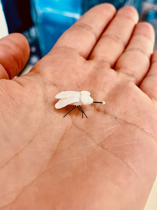 white porcelain ceramic housefly in palm of hand