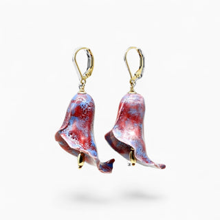 A pair of dangling calla lilly-shaped earrings with a marbled red, purple, and blue glass finish, suspended from gold leverbacks 