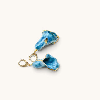 A pair of handmade calla lily earrings with textured teal glass, finished with gold leaf detailing and gold-tone metal findings