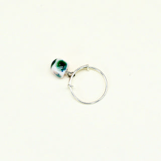 Silver adjustable ring with a green porcelain bead on a white background
