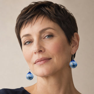 A close-up portrait of a woman with pixie haircut wearing dangling blue porcelain earrings - absolutely unique gift for your wife.