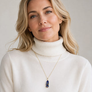 Blue porcelain botanical necklace worn with a white rollneck, a distinctive anniversary gift for her
