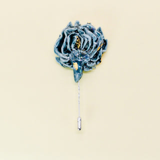 Teal green artichoke floral doublesided lapel pin on a beige background