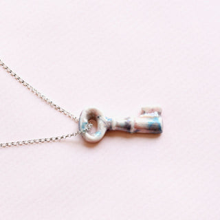 Silver key-shaped porcelain pendant on a chain as a perfect birthday gift