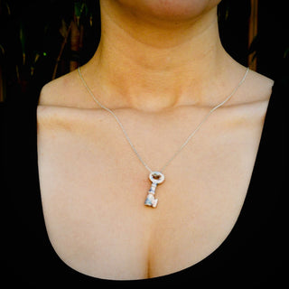 Silver necklace with a key-shaped pendant on a model's neck for 18th wedding anniversary