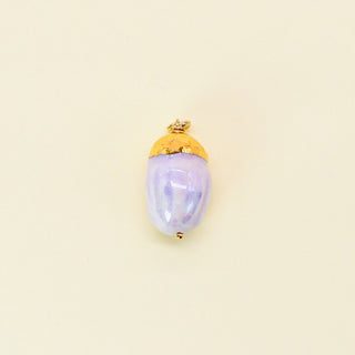 Elegant pendant resembling an acorn with a gold cap and blush body on a beige background