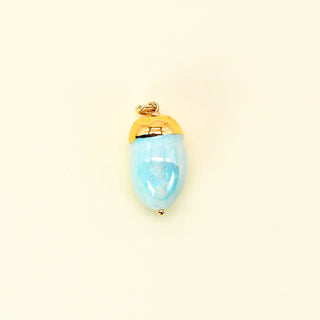 Gold-accented minty blue acorn pendant made from glossy porcelain on a beige background