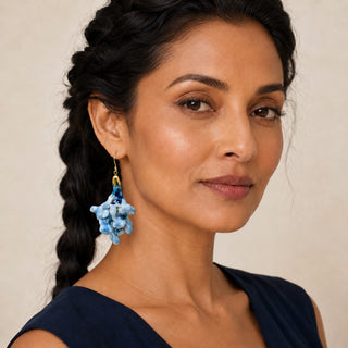 A close-up portrait of a woman wearing a dangling porcelain earrings handmade from real flowers - beautiful gift for wife.